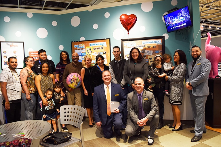 The Bob's staff and members of the Salvation Army and families receiving a furniture donation pose for a photo.