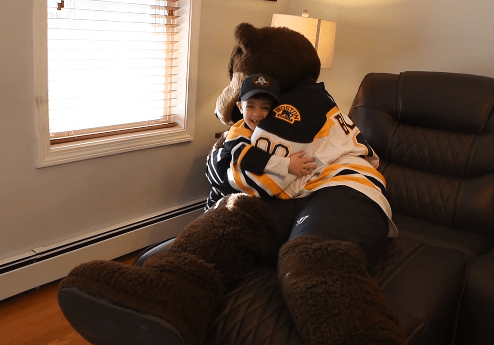 Grant Medeiros hugs Blades, the Boston Bruins mascot | Bob's Discount Furniture