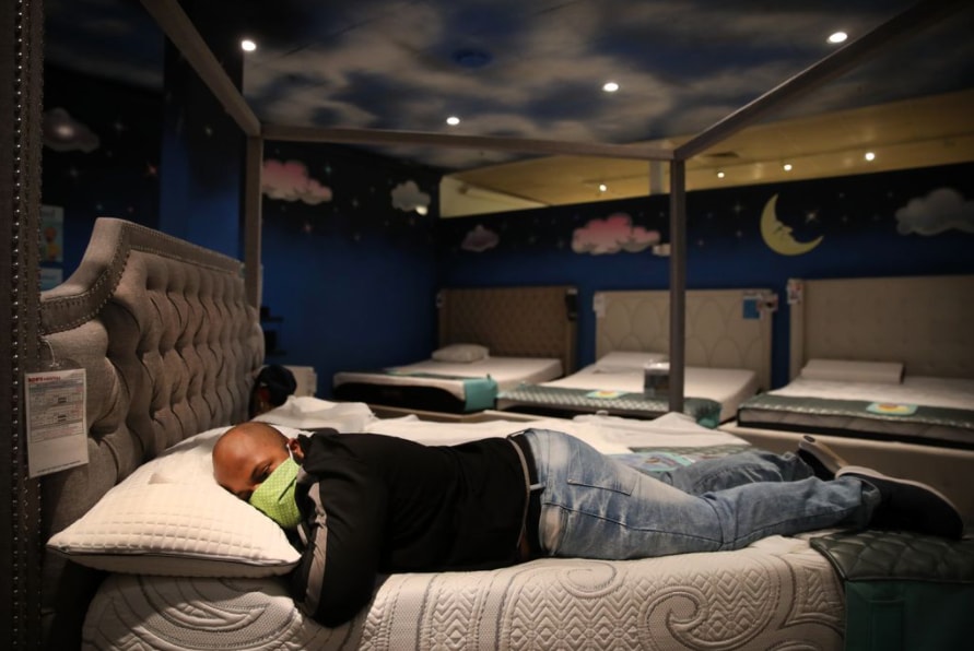 A customer tests a bed at Bob’s Discount Furniture in Nashua, New Hampshire.