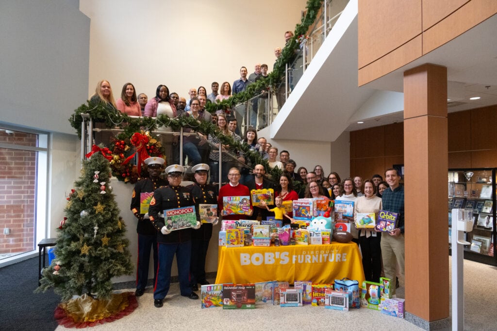 Members of Bob's staff, including Bill Barton, President and CEO, Pat Davies, Senior Vice President, Chief Human Resources Officer, and Carl Lukach, Chief Financial Officer, pose with SSgts. Cummings, Pacheco, and Rivera from Tots for Tots Plainville picked up toys in Bob's Home Office in Connecticut.